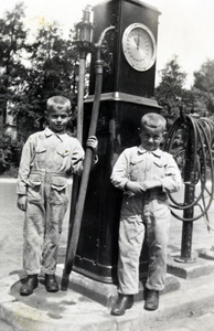 811683 Afbeelding van Co (1929) en Herman (1931) Jongerius naast een benzinepomp van het garagebedrijf van hun vader ...